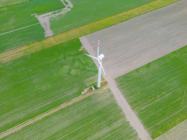 Rüzgar enerjili türbinlerin hava aracı görüntüsü, bir rüzgar çiftliğinin parçası. Kırsal bölgedeki yeşil alanda rüzgar türbinleri. Rüzgar santrali.