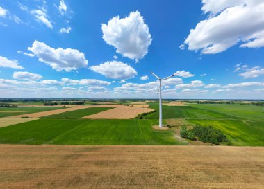 Rüzgar enerjili türbinlerin hava aracı görüntüsü, bir rüzgar çiftliğinin parçası. Kırsal bölgedeki yeşil alanda rüzgar türbinleri. Rüzgar santrali.
