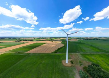 Yükseklerdeki bulutlu gökyüzünde enerji üretimi için güçlü rüzgar türbini çiftliğinin hava manzarası. Rüzgar güç türbinleri sürdürülebilir kalkınma için temiz yenilenebilir enerji üretiyor.