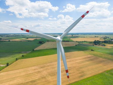 Yükseklerdeki bulutlu gökyüzünde enerji üretimi için güçlü rüzgar türbini çiftliğinin hava manzarası. Rüzgar güç türbinleri sürdürülebilir kalkınma için temiz yenilenebilir enerji üretiyor.