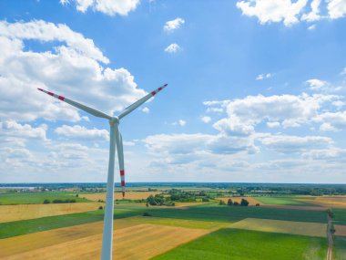 Yükseklerdeki bulutlu gökyüzünde enerji üretimi için güçlü rüzgar türbini çiftliğinin hava manzarası. Rüzgar güç türbinleri sürdürülebilir kalkınma için temiz yenilenebilir enerji üretiyor.