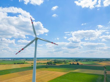 Yükseklerdeki bulutlu gökyüzünde enerji üretimi için güçlü rüzgar türbini çiftliğinin hava manzarası. Rüzgar güç türbinleri sürdürülebilir kalkınma için temiz yenilenebilir enerji üretiyor.