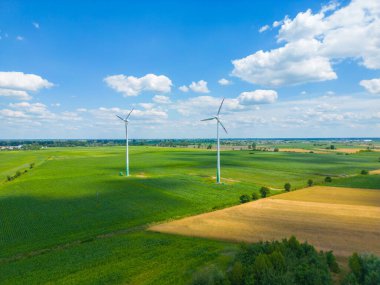 Yükseklerdeki bulutlu gökyüzünde enerji üretimi için güçlü rüzgar türbini çiftliğinin hava manzarası. Rüzgar güç türbinleri sürdürülebilir kalkınma için temiz yenilenebilir enerji üretiyor.