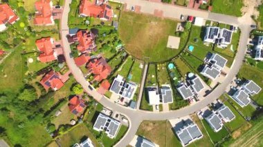 Gün batımında mahalle ve apartman kompleksinin havadan görüntüsü. Sıkışık evler, garaj yolu yeşil ağaç üstgeçidini çevreleyen Suburban konutları
