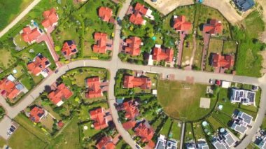 Gün batımında mahalle ve apartman kompleksinin havadan görüntüsü. Sıkışık evler, garaj yolu yeşil ağaç üstgeçidini çevreleyen Suburban konutları