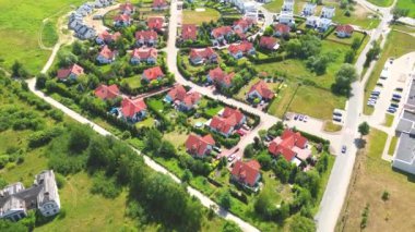 Gün batımında mahalle ve apartman kompleksinin havadan görüntüsü. Sıkışık evler, garaj yolu yeşil ağaç üstgeçidini çevreleyen Suburban konutları