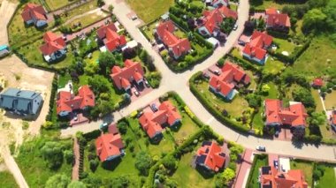 Gün batımında mahalle ve apartman kompleksinin havadan görüntüsü. Sıkışık evler, garaj yolu yeşil ağaç üstgeçidini çevreleyen Suburban konutları