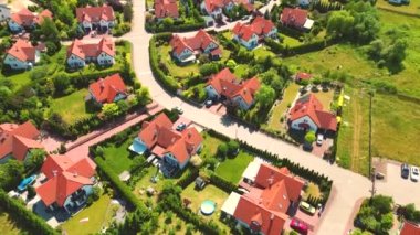 Gün batımında mahalle ve apartman kompleksinin havadan görüntüsü. Sıkışık evler, garaj yolu yeşil ağaç üstgeçidini çevreleyen Suburban konutları