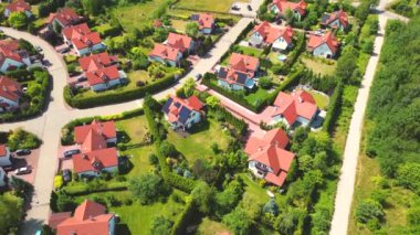 Gün batımında mahalle ve apartman kompleksinin havadan görüntüsü. Sıkışık evler, garaj yolu yeşil ağaç üstgeçidini çevreleyen Suburban konutları