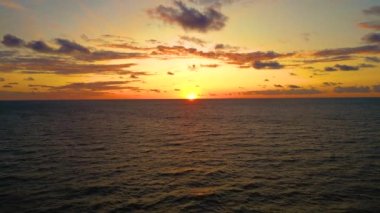 Aerial view of sunset horizon over the sea. Cinematic drone aerial view beautiful evening sunset in sky over sea. Sun path is reflected in sea surface. Nature beauty.