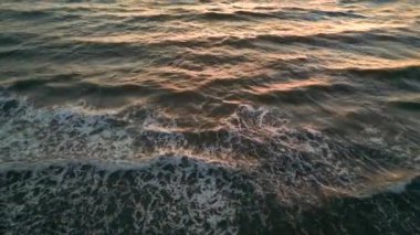 Okyanus suyunun üzerinde tropik altın gün batımı yavaş çekim hava manzarası. Güneş deniz manzarasına yansıyor. Sea Bay 'de kimsenin olmadığı bir kumsal. Güneşli bir akşamda sakin bir su manzarası. Yaz tatili. Tropik tatil