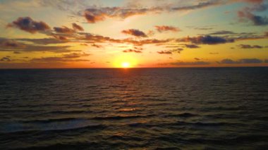 Aerial view of sunset horizon over the sea. Cinematic drone aerial view beautiful evening sunset in sky over sea. Sun path is reflected in sea surface. Nature beauty.