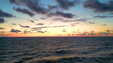 Sea scenery. Drone view. Sunset horizon. Nature beauty. Water landscape. Blue ocean waves relaxing motion on red orange sun light skyline background aerial shot.