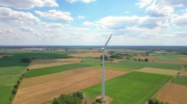 Yükseklerdeki bulutlu gökyüzünde enerji üretimi için güçlü rüzgar türbini çiftliğinin hava manzarası. Rüzgar güç türbinleri sürdürülebilir kalkınma için temiz yenilenebilir enerji üretiyor.