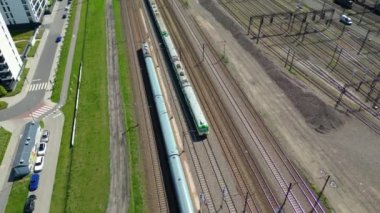 Şehir üzerinde ağaçlarla çevrili tren raylarında Sunset 'e doğru giden Yolcu Treninin Manzaralı Çekimi