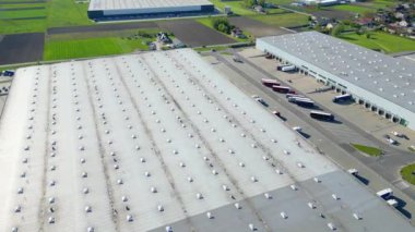 Dağıtım merkezinin hava görüntüsü, endüstriyel lojistik bölgesinin İHA fotoğrafı, modern teknoloji ve robotlarla dolu yeni süper modern lojistik merkezi, yeşil enerji üretimi için çatı güneş enerjisi santrali.