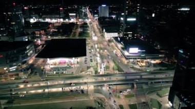 Şehir merkezindeki Varşova şehrinde gece hava trafiği ve insanlar karşıdan karşıya geçiyor. Hava aracının üst görüntüsü, yukarı doğru uçun. Banliyö, Avrupa şehir yaşamı veya toplu taşıma kavramı