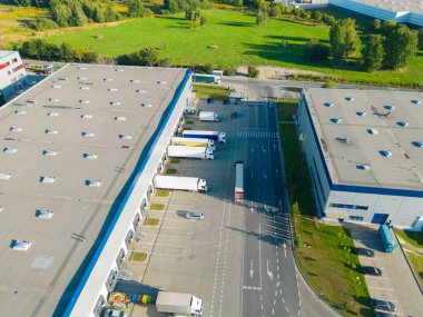 Malzeme deposunun havadan görüntüsü. Sanayi bölgesindeki lojistik merkezi yukarıdan. Lojistik merkezde yüklenen kamyonların hava görüntüsü