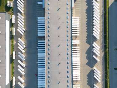 Malzeme deposunun havadan görüntüsü. Sanayi bölgesindeki lojistik merkezi yukarıdan. Lojistik merkez stok fotoğrafına yüklenen kamyonların hava görüntüsü
