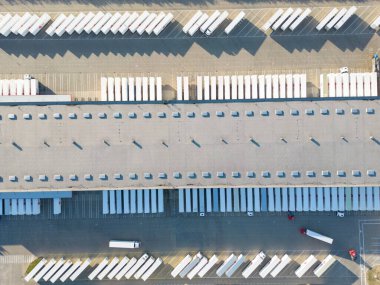 Malzeme deposunun havadan görüntüsü. Sanayi bölgesindeki lojistik merkezi yukarıdan. Lojistik merkez stok fotoğrafına yüklenen kamyonların hava görüntüsü