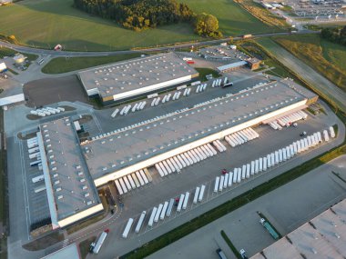 Malzeme deposunun havadan görüntüsü. Sanayi bölgesindeki lojistik merkezi yukarıdan. Lojistik merkezde yüklenen kamyonların hava görüntüsü. İnsansız hava aracından görüntüle.