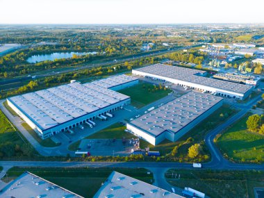 Malzeme deposunun havadan görüntüsü. Sanayi bölgesindeki lojistik merkezi yukarıdan. Lojistik merkezde yüklenen kamyonların hava görüntüsü. İnsansız hava aracından görüntüle.