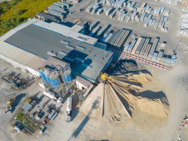 Gün batımında yükleme / boşaltma malları için rampalarda bekleyen depo, merkez ve kargo karavanıyla lojistik parkının hava görüntüsü.