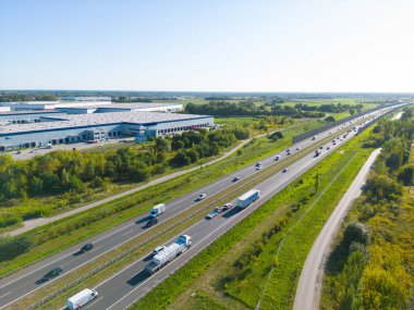 Depoyla birlikte lojistik parkı. Yarı karavan kamyonları araba parkında duruyor ve yükleme ve boşaltma için rampalarda bekliyorlar. Hava görünümü