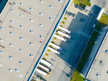 Malzeme deposunun havadan görüntüsü. Sanayi bölgesindeki lojistik merkezi yukarıdan. Lojistik merkezde yüklenen kamyonların hava görüntüsü