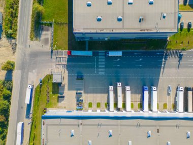 Malzeme deposunun havadan görüntüsü. Sanayi bölgesindeki lojistik merkezi yukarıdan. Lojistik merkezde yüklenen kamyonların hava görüntüsü