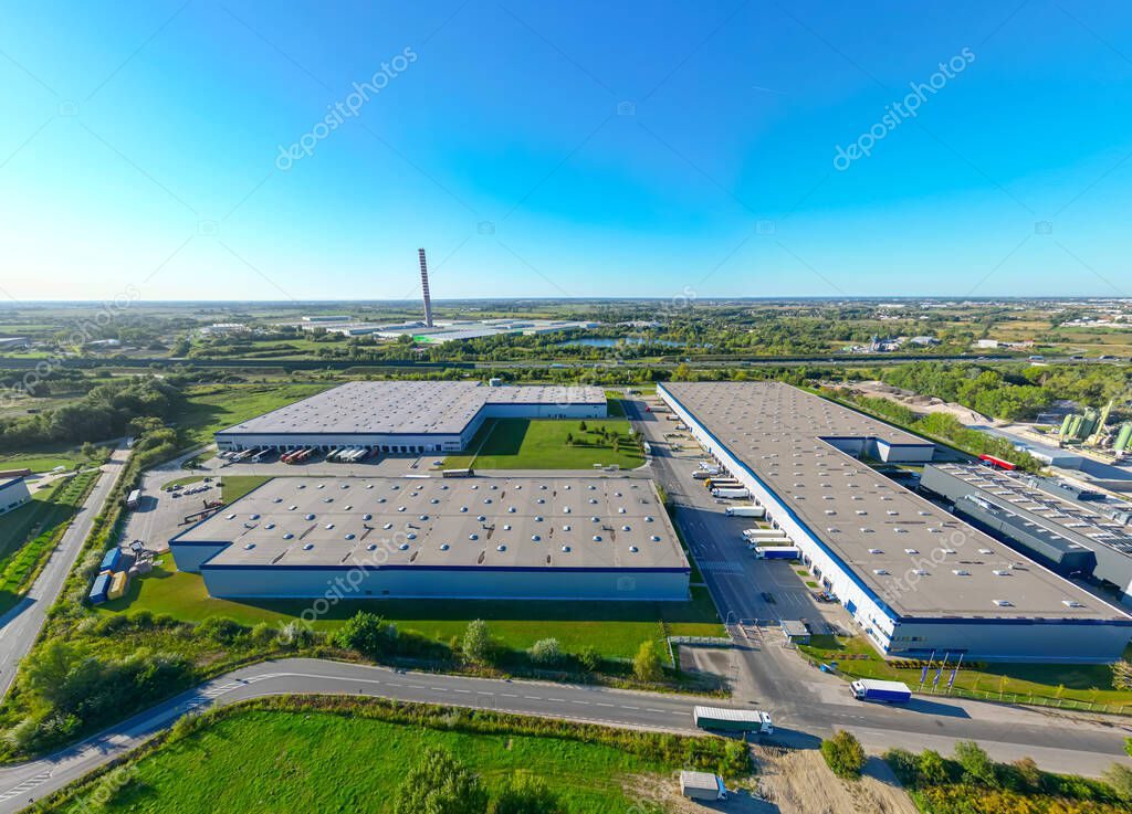 Aerial view of goods warehouse. Logistics center in industrial city zone from above. Aerial view of trucks loading at logistic center stock photo