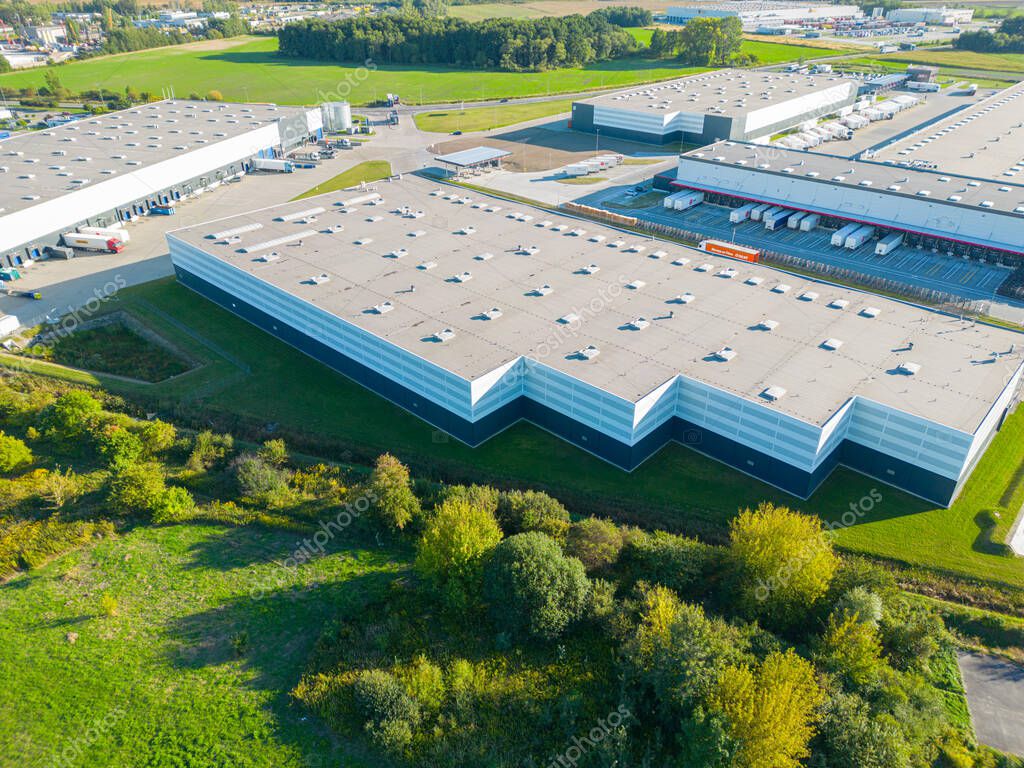 Aerial view of goods warehouse. Logistics center in industrial city zone from above. Aerial view of trucks loading at logistic center stock photo