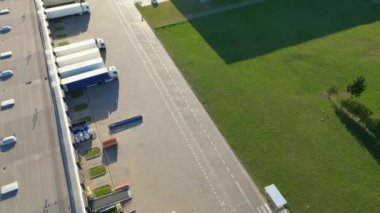 Aerial view of goods warehouse. Logistics center delivery in industrial city zone from above. Aerial view of trucks loading at logistic center