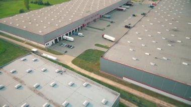 Aerial view of goods warehouse. Logistics center delivery in industrial city zone from above. Aerial view of trucks loading at logistic center