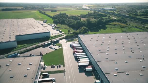 商品倉庫の空中ビュー 上記から工業都市ゾーンの物流センター 物流センターにおける荷役トラックの空中図 — ストック動画