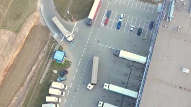 Depo rampalarında durmakta olan kargo römorklu bir tırın hava görüntüsü. Yükleme merkezli büyük lojistik parkındaki malları yüklemek / boşaltmak için.