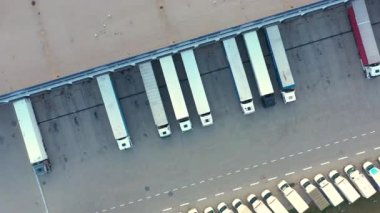 Depo rampalarında durmakta olan kargo römorklu bir tırın hava görüntüsü. Yükleme merkezli büyük lojistik parkındaki malları yüklemek / boşaltmak için.