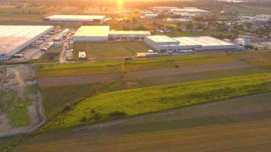 Aerial view of a semi trucks with cargo trailers standing on warehouses ramps for loading/unloading goods on the big logistics park with loading hub