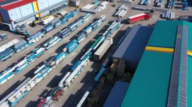 Depo rampalarında durmakta olan kargo römorklu bir tırın hava görüntüsü. Yükleme merkezli büyük lojistik parkındaki malları yüklemek / boşaltmak için.