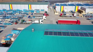 Depo rampalarında durmakta olan kargo römorklu bir tırın hava görüntüsü. Yükleme merkezli büyük lojistik parkındaki malları yüklemek / boşaltmak için.