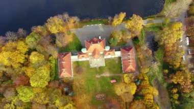 İsveç 'teki güzel sarayın hava manzarası. Sonbahar günbatımı. Sonbahar ormanındaki beyaz saray. Yüksek irtifa.