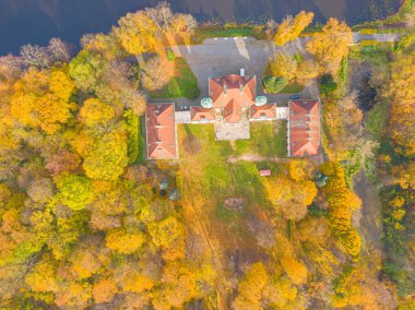 Sonbahar günbatımında güzel sarayın hava manzarası. Sonbahar ormanındaki beyaz saray. Yüksek irtifa.
