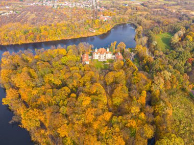 Sonbahar günbatımında güzel sarayın hava manzarası. Sonbahar ormanındaki beyaz saray. Yüksek irtifa.
