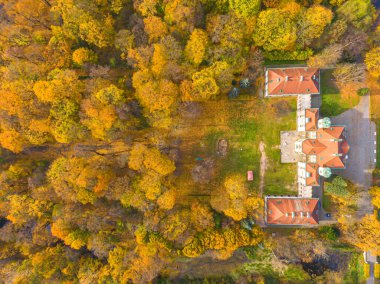 Sonbahar günbatımında güzel sarayın hava manzarası. Sonbahar ormanındaki beyaz saray. Yüksek irtifa.