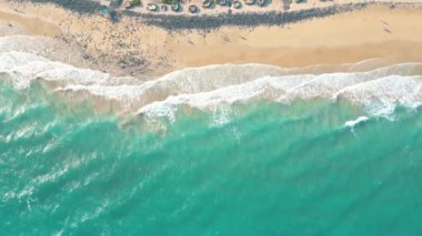 Okyanusun arka planında okyanus suyunun beyaz dalgasının açık denize vuruşunu gösteren muhteşem bir hava manzarası. Kuş bakışı dalgalarda deniz dalgalarının uzaktan kumandalı fotoğraf arkaplanı.