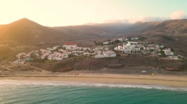 Muhteşem mor gökyüzü ile muhteşem bir gün batımı su havuzlarına ve İspanya 'nın ıssız Kanarya Adaları' ndaki temiz kum yüzeyine yansıyor. İnanılmaz Esquinzo plajı arka planda ve Atlantik Okyanusu 'nda.