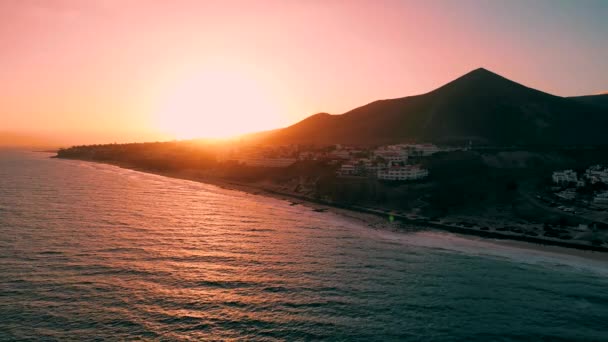 迷人的落日与壮观的紫色天空映入水池和西班牙加那利群岛上整洁的沙滩表面 背景中令人惊奇的爱斯基诺海滩和大西洋 — 图库视频影像