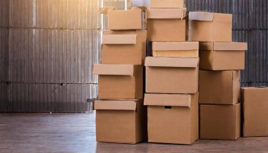 Bu resim düzgünce düzenlenmiş karton kutular sergiliyor, nakliye ve depolama amacıyla ideal. Kutular şekil ve boyut olarak farklılık göstererek farklı nesneleri etkili bir şekilde paketlemek için çok yönlülülüklerini gösterir..
