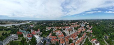 Bu nefes kesen hava manzarası, Wila nehrinin kıyıları boyunca uzanan Sandomierz Eski Kasabası 'nın tarihsel cazibesini yansıtır. Eski kasaba ikonik bir köprüyle birbirine bağlı.,.