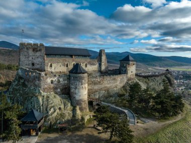 Aerial view of partially restored Boldogko, medieval Gothic castle in Borsod county Hungary with round gate tower, donjon cloudy blue sky background